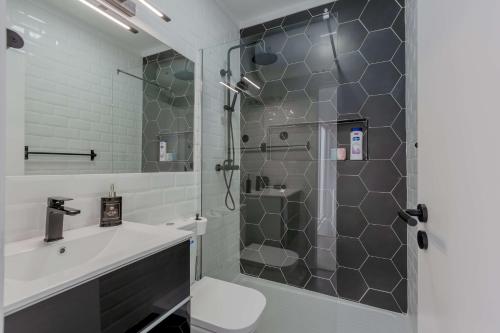 uma casa de banho com um chuveiro, um WC e um lavatório. em Suprema Lofts III em Lisboa