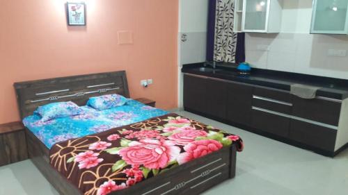 a bedroom with a bed with flowers on it at Studio Apartment On The Lake in Lavasa