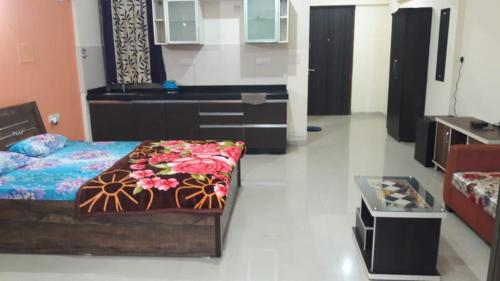 a room with a bed and a table in it at Studio Apartment On The Lake in Lavasa