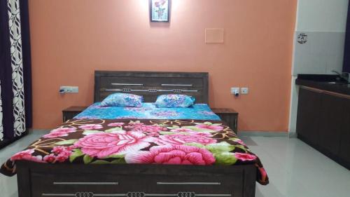 a bedroom with a bed with a floral bedspread on it at Studio Apartment On The Lake in Lavasa