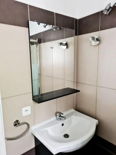 une salle de bain avec un lavabo blanc et un miroir dans l'établissement Petit Nid à Tarco Chez Catherine et Rémy, à Conca