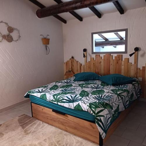 une chambre avec un lit avec une tête de lit en bois dans l'établissement Petit Nid à Tarco Chez Catherine et Rémy, à Conca