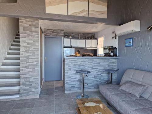 un salon avec un canapé et une cuisine dans l'établissement Petit Nid à Tarco Chez Catherine et Rémy, à Conca