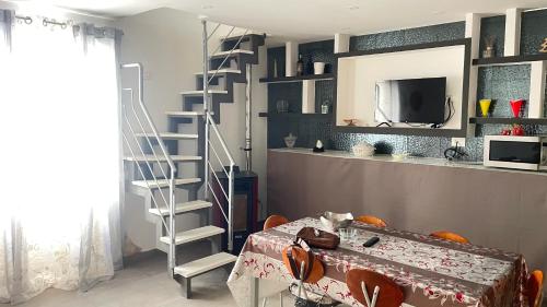 sala de estar con escalera y mesa en La Maison2, en Mondragone
