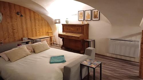 uma sala de estar com uma cama e um piano em Maison à Tour Briançon em Briançon