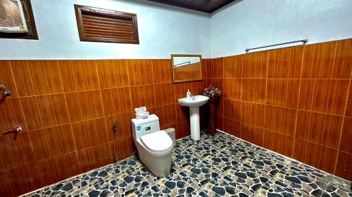 La salle de bains est pourvue de toilettes et d'un lavabo. dans l'établissement ณ พรศุภะ เซรามิคคาเฟ่, 