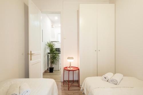 ein Schlafzimmer mit 2 Betten und einem Tisch mit einer Lampe in der Unterkunft Centric Apartment Molino P3 in Barcelona