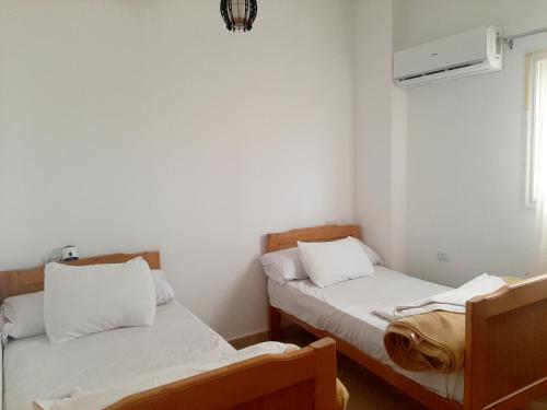 two beds in a small room with a window at Alam B&B in Marsa Alam City