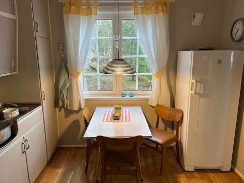 une cuisine avec une table et des chaises ainsi qu'une fenêtre dans l'établissement Kleiva 8 Skorovas, à Namsskogan