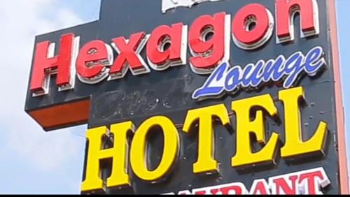 um sinal para um hotel em língua havaiana em Hexagon Hotel Lounge & Restaurants. em Asi