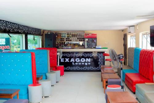 una stanza con sedie rosse e blu e un bar di Hexagon Hotel Lounge & Restaurants. ad Asi