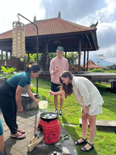 a group of people standing around a pot at Munduk Tentrem Resort in Munduk
