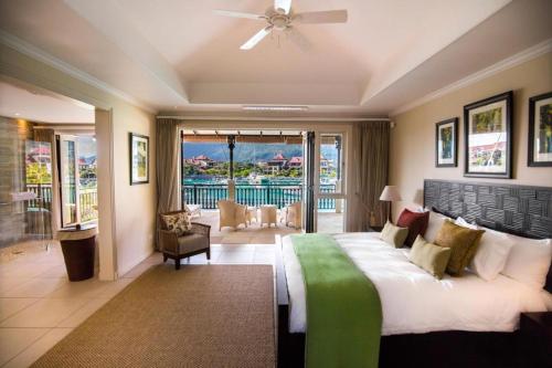 sypialnia z dużym łóżkiem i balkonem w obiekcie Eden Island Luxury Ocean Front Villa with Pool w Victorii