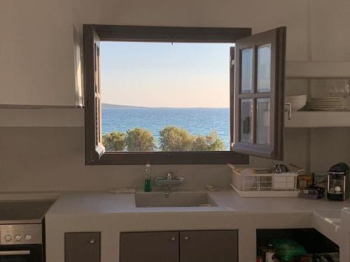 a kitchen with a window with a view of the ocean at The Blue Lagoon Apartment in Aliki