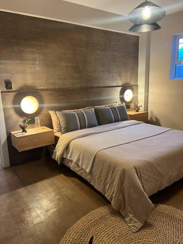 una camera da letto con un grande letto con due luci sopra di AfroJapandi Apartment a Durban