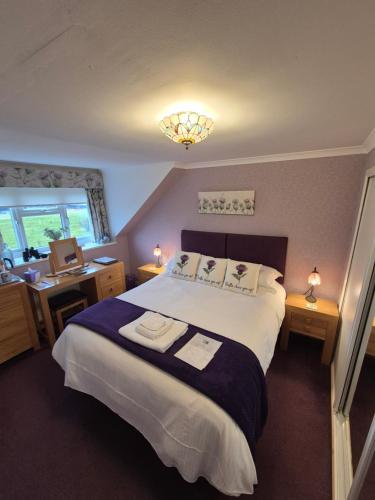 a bedroom with a bed and a desk with a sink at Montague Villa in Dunoon