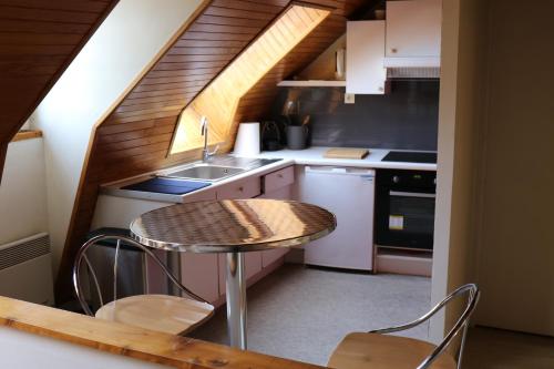 a small kitchen with a table and a sink at Les rives de l'odet, vue rivière in Quimper