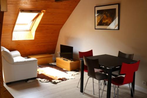 a dining room with a table and red chairs at Les rives de l'odet, vue rivière in Quimper