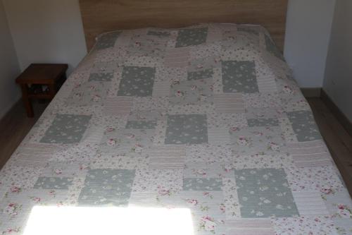 a bed with a quilt on it in a room at Les rives de l'odet, vue rivière in Quimper