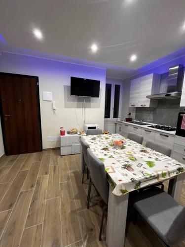 a kitchen with a table with chairs and a tv at PARADISO HOME in Augusta