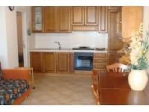 una cucina con armadi in legno e tavolo con sidro da tavolo di House Pedone a Otranto