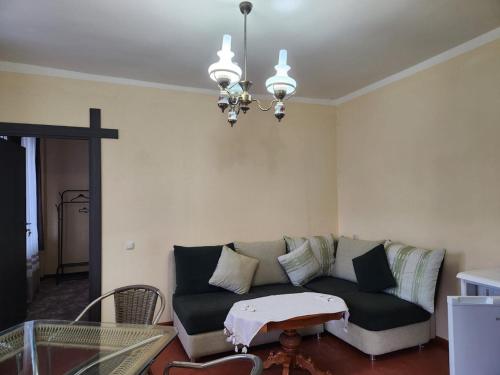 a living room with a couch and a chandelier at Garni Nature Villa in Garni
