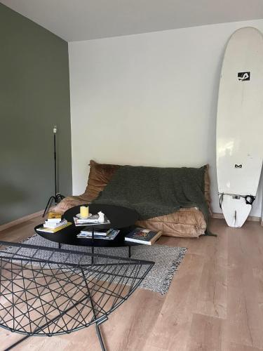 a living room with a table and a surfboard at Line in Le Bouscat