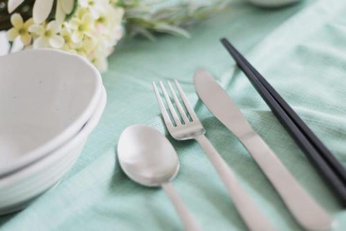 a table with a table cloth with a fork and knife at bHOTEL Yutori - Near Temples 1BR in Onomichi City for 3 Ppl in Onomichi