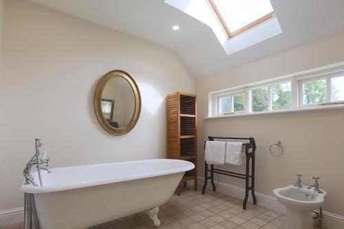 a bathroom with a large white tub and a sink at Tranquil 18th Century with tennis court in Malahide