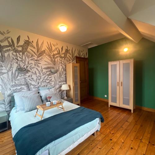 - une chambre avec un grand lit et une fresque murale dans l'établissement La villa du parc, à Desvres
