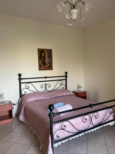 Schlafzimmer mit einem Bett mit rosa Tagesdecke in der Unterkunft Casa Vacanze Paradise in Santa Maria La Carità