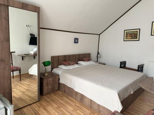 a bedroom with a bed and a large mirror at Hotel Home in Tbilisi City