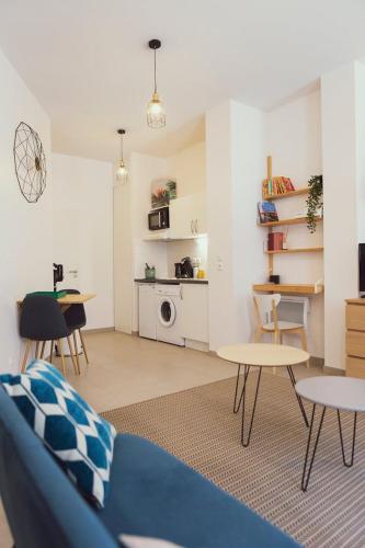 un salon avec un canapé bleu et une table dans l'établissement Matabiau station SNCF - City center, à Toulouse