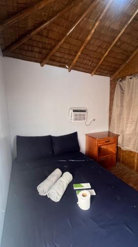 a blue bed with two rolled up towels on it at L Cafe Restobar & Lyn's Guest House in San Juan