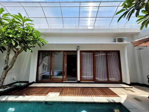 a house with a swimming pool in front of it at Villa Moana Sari in Senggigi 