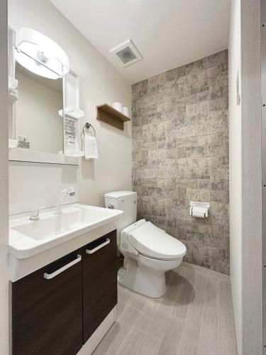 a bathroom with a white toilet and a sink at bHOTEL Yutori - Simple 1BR Apartment in Onomichi for 3 Ppl in Onomichi