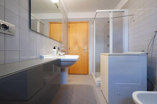Un baño con lavabo, inodoro y espejo. en Cesa Azola, en Vigo di Fassa