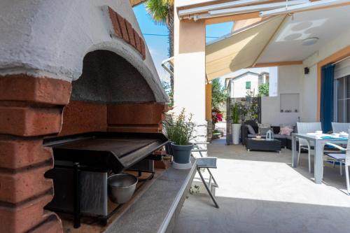 an outdoor pizza oven on the side of a house at Apartment Marangunija in Malinska