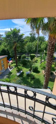 a view from a balcony of a yard with palm trees at Apartment Marangunija in Malinska