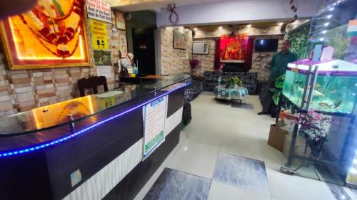 a restaurant with a bar with a fish tank at Goroomgo Mayagiri Patna in Patna