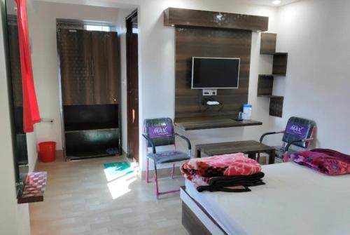 パトナーにあるGoroomgo Mayagiri Patnaのベッドルーム1室(ベッド2台、デスク、椅子2脚付)