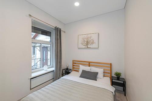 a bedroom with a bed and a window at City Centre 3BD Apartment by Hostlovers in Kaunas