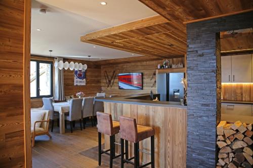 - une cuisine et une salle à manger avec un bar et des tabourets dans l'établissement Chalet Shangrila, aux Angles