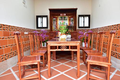 uma sala de jantar com uma mesa de madeira e cadeiras em 木馬丑盒子古厝民宿 Troy Droll Bin em Jinhu
