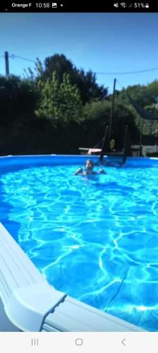 une personne nageant dans une grande piscine bleue dans l'établissement L'Annexe, à Maël-Pestivien