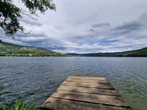 a wooden dock on a lake on a cloudy day at Casa do Barqueiro LOUREIRA in Castrelo de Miño