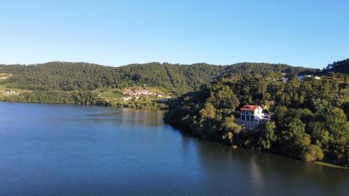 an aerial view of a lake with houses and trees at Casa do Barqueiro LOUREIRA in Castrelo de Miño
