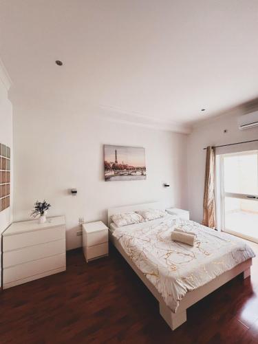 a white bedroom with a large bed and a window at Pembroke Parkside Maisonette in Pembroke 