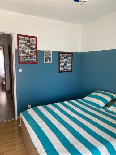 a blue bedroom with a bed with blue and white stripes at Appartement au cœur de Seyne in Seyne