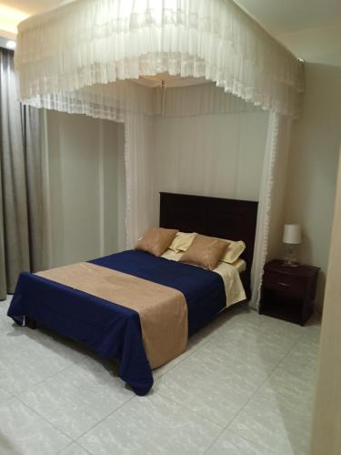 a bedroom with a large bed with a canopy at SHOAL Apartments, Mawanda Road in Kampala
